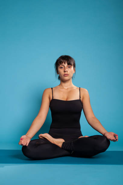 istock Personal trainer sitting on yoga mat in lotus position 1485110122