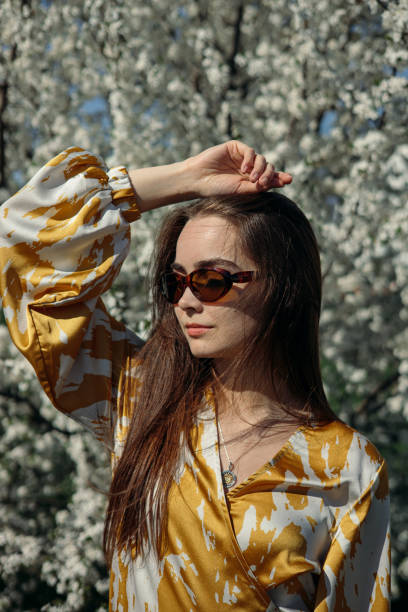 istock Serene female model in park with flowering tree on sunny day 1485111390