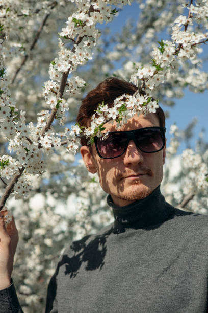 istock Handsome male near blooming tree in spring garden 1485111416