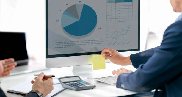 istock Two business teamwork calculating a business valuation in workplace, using desktop computer analyzing graph chart. 1485112613