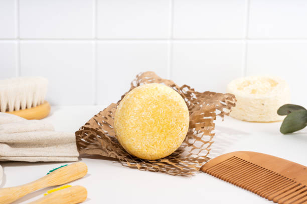 istock Eco friendly solid shampoo bar and spa accessories in the bathroom. Plastic free, zero waste, low water ingredients. composition on a white ceramic background. Sustainable hair care 1485113552