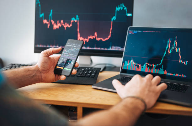 istock Man looking at currency trading app on his smart phone from his home office. 1485116020