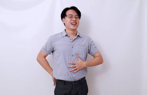 istock Satisfied asian man standing while holding his tummy. He feels full. Isolated on white 1485119371