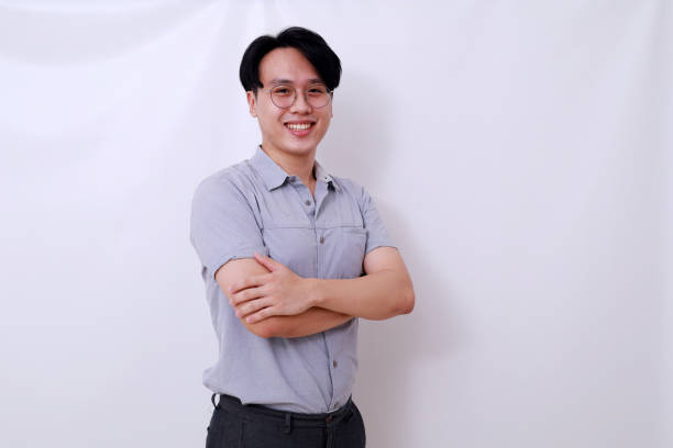 istock Happy Asian handsome man standing with folded hands. Isolated on white 1485119410