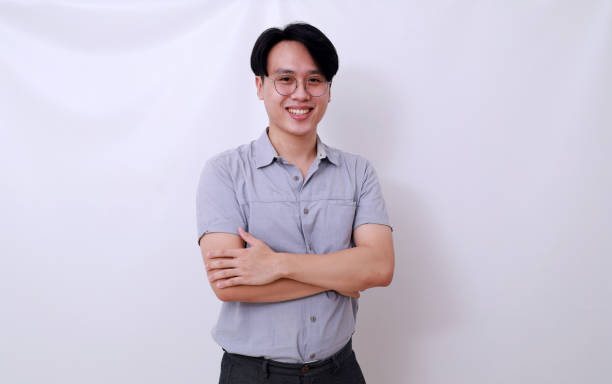 istock Handsome asian man standing with folded hand while looking at the camera. Isolated on white 1485119655