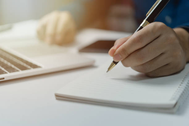 istock Hands Writing with Pen on Notebook. concept of work, study, and education. 1485121015