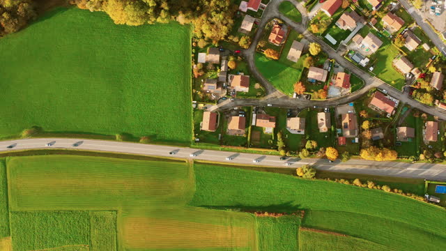 Drone shot aerial view of Beautiful small village or township in the autumn mountain forest sunset,sunset Flying over suburban france, apartment buildings, villas, road