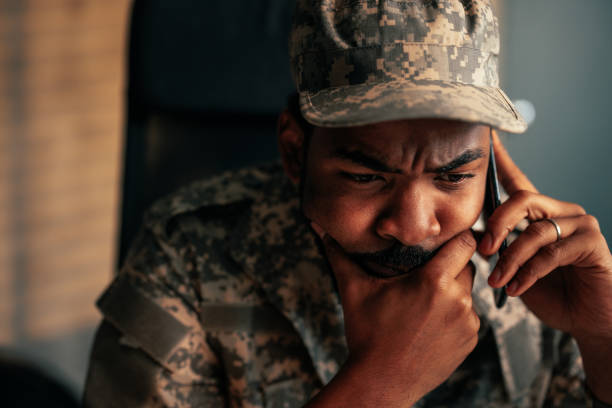 istock Worried army officer using mobile phone in office. 1485123013