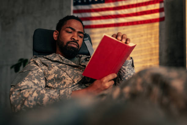 Military officer reading book in office.
