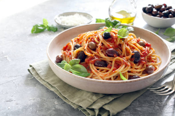 istock Pasta with tomato sauce, dark olive and parmesan cheese on light background. 1485123877