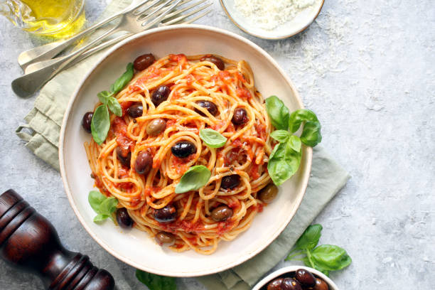 istock Pasta with tomato sauce, dark olive and parmesan cheese on light background. 1485123886