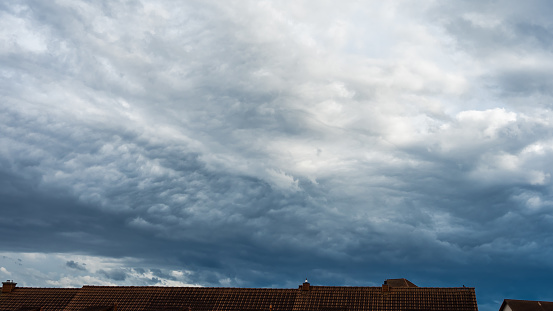 Sky sights, ominous dark storm clouds over house roof, heaven scenes