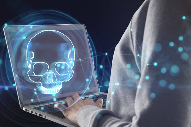istock Hacker using laptop with digital blue skull hologram on dark background. Ransomeware, virus and pirate threat concept. Double exposure. 1485130530