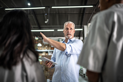 Senior businessman talking to employees at the supermarket