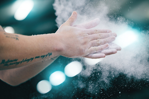 Sports, gymnastics and hands with chalk powder for competition, performance and challenge in gym. Fitness, motivation and zoom of gymnast athlete clap palms to start exercise, workout and training