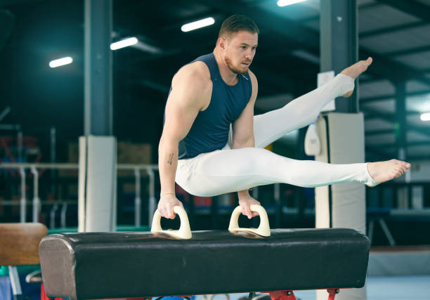 istock Gymnastics, practice and man training for a competition, performance and exercise in a gym. Focus, fitness and athlete gymnast doing a movement with balance, strength and artistic with flexibility 1485134397