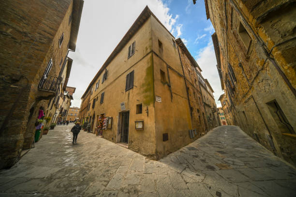 View of a narrow stone street flanked by historic buildings in Florence, Italy. The street appears empty, emphasizing the architectural details of the surrounding structures. The cobblestone path leads through the historic center, capturing the essence of Florence's charm.