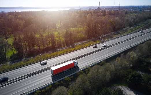 Backlit scenery with highway and red trailer