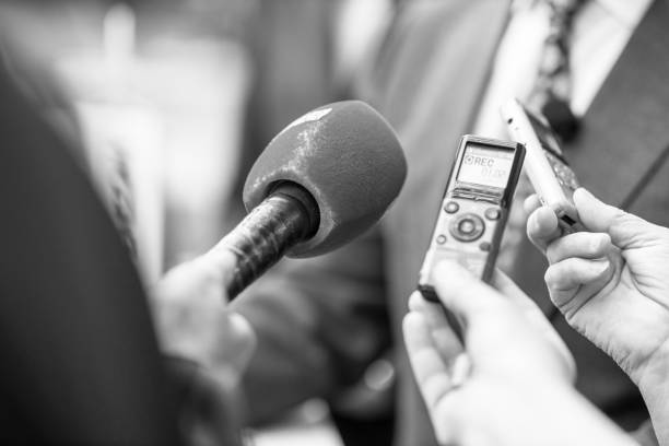 istock News or press conference or media interview, digital voice recorder and microphone in focus 1485137549
