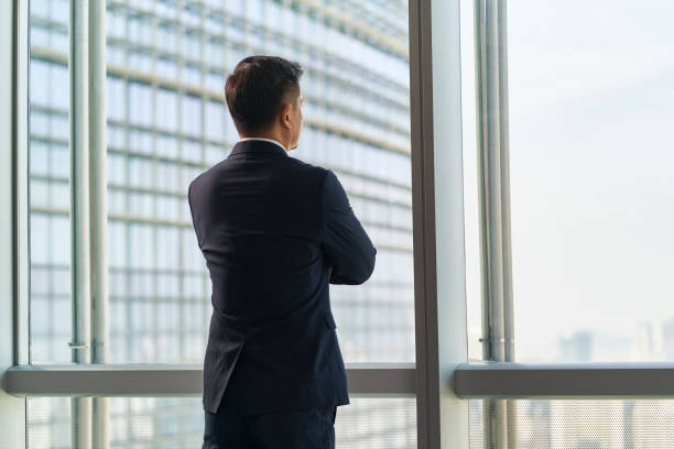 istock asian businessman standing by window looking at view 1485138787