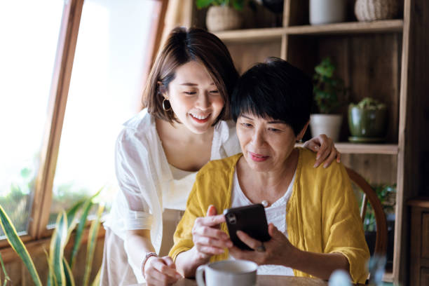 istock Affectionate Asian senior mother and daughter using smartphone together at home, smiling joyfully, enjoying mother and daughter bonding time. Multi-generation family and technology 1485140178