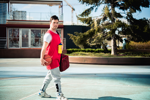 Happy Young Man With Down Syndrome Playing Basketball Outside Stock