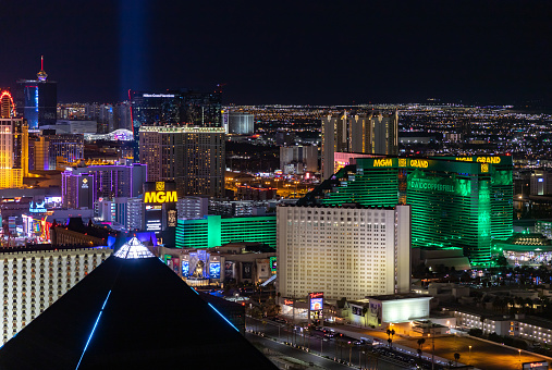 Las Vegas, Nevada/ USA - March 14, 2022: Aerial view of The Strat observation tower and surrounding hotels at night.\n\nLas Vegas is the largest city in the US state of Nevada and a world-renowned center for gambling, shopping, fine dining and entertainment. It is mainly famous for its many casinos and the accompanying entertainment-tourism activities, which earned it the nickname of the Entertainment Capital of the World.