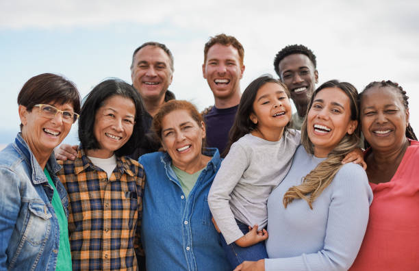 istock Group of multigenerational people hugging each other while smiling on camera - Multiracial friends having fun together outdoor 1485140963