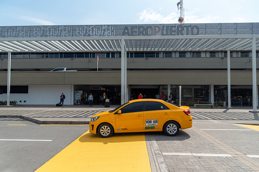 yellow taxi passing in front of the facade of the Alfonso Bonilla Aragón International Airport. Valle del Cauca. Colombia July 8, 2022.