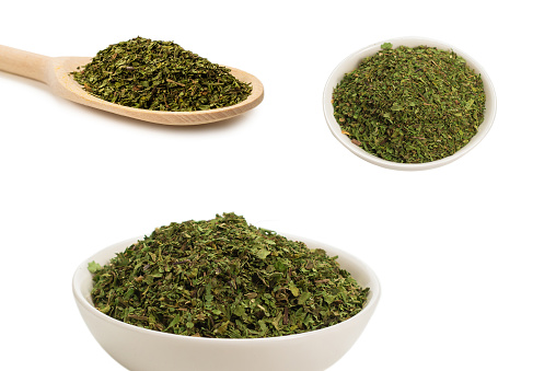 Oregano in a bowl isolated on white background.