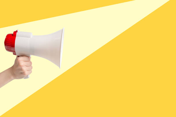 istock Megaphone in woman hands on a yellolw background. 1485149269