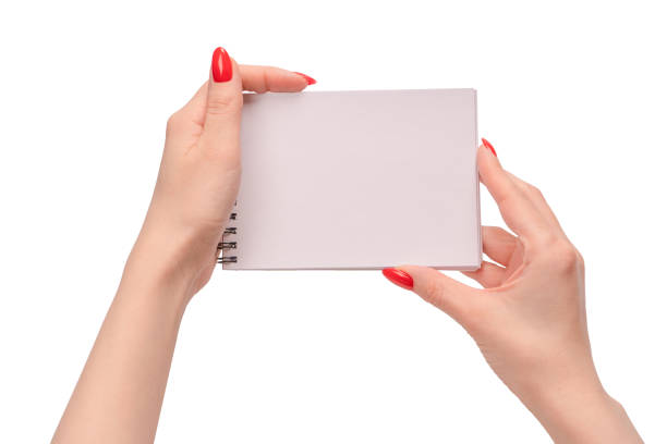 istock A notebook with empty white paper in woman hands with red nails. 1485149280