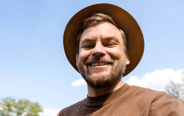 istock Bearded man wearing straw hat looking at camera and smiling. 1485151215