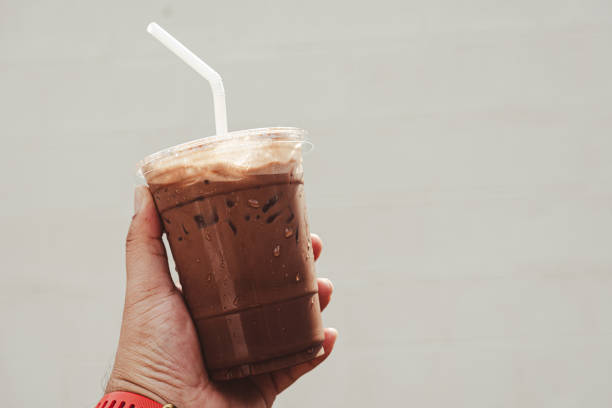 istock Man holding an iced Mocha coffee in a plastic to-go cup 1485151326