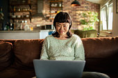 Young Japanese Woman using a laptop on a couch