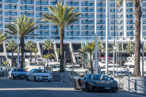Vilamoura, Algarve, Portugal - April 25, 2023: Luxurious cars parked next to the Vilamoura Marina in Algarve, Portugal
