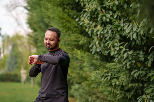 Man doing outdoor sports to stay healthy, using his digital watch