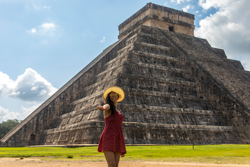 Young tourist enjoying and visiting the castle of Chichen Itza, the famous Mayan pyramid of Mexico, belonging to the Mayan culture and civilization. Travel concept.