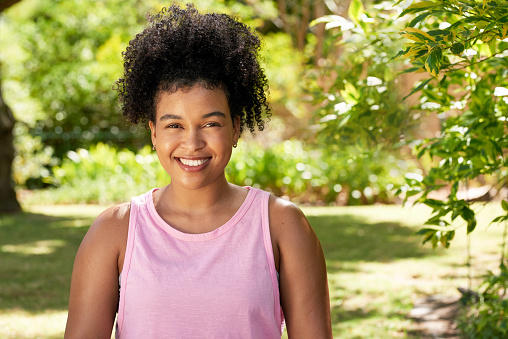Portrait of a beautiful young multi-ethnic woman smiling in garden park outdoors. High quality photo