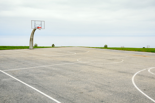 Empty basketball court overlooking the ocean on a cloudy and foggy autumn morning. Los Angeles, CA, USA.