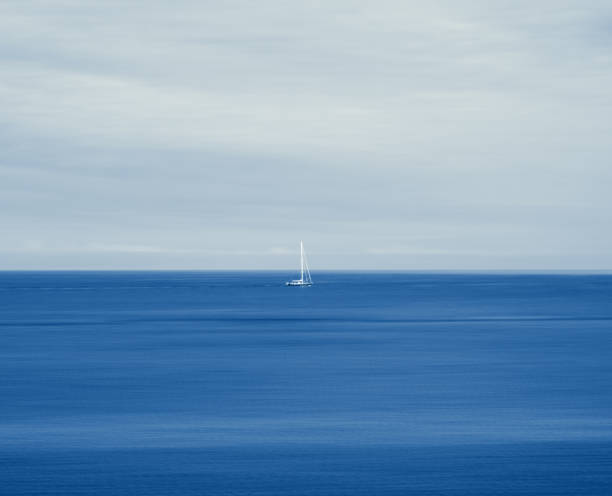 動く海での孤独な帆船 - zen like sea horizon over water blurred motion ストックフォトと画像