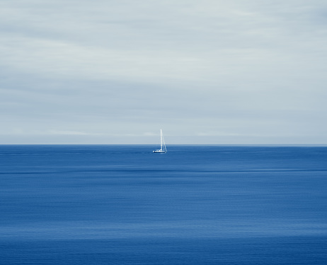 While the sailing boat is kept still in the centre of the frame, there is motion blur for the sea