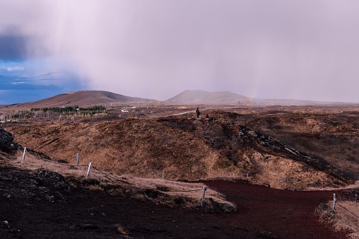 A majestic Icelandic mountain ranges, showcasing the vibrant red hues of the soil in the fields