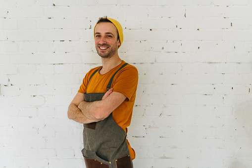 Portrait of a young male chef wearing an apron, on a white background.