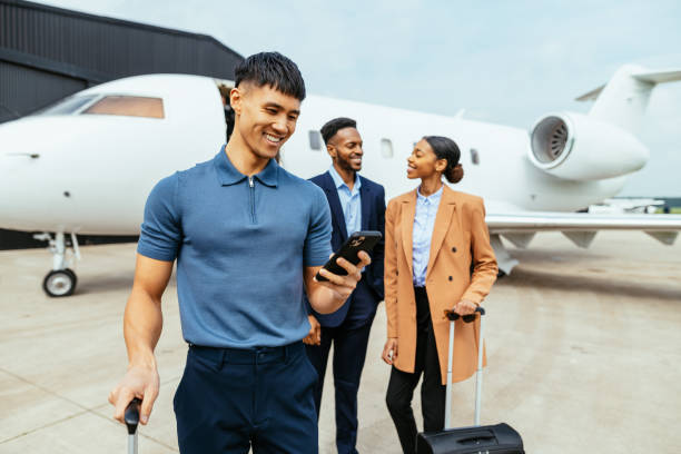 istock Passengers in front of the private luxury jet, Chinese man using smart phone and smiling 1485177237