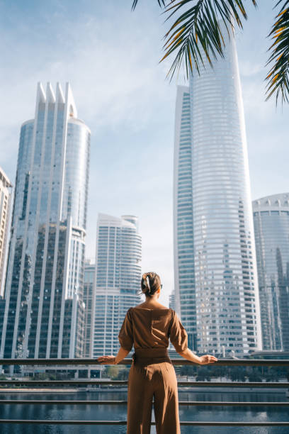 현대 도시 배경 앞에서 잘 차려입은 여자 - dubai skyscraper architecture united arab emirates 뉴스 사진 이미지