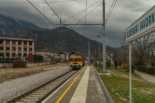 Working train in station in cloudy spring dark day in Slovenski Javornik 03 31 2023