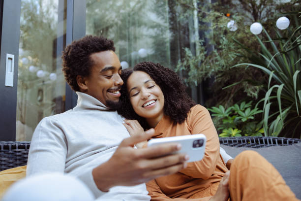 istock African American young couple using smart phone and enjoying in the backyard 1485180003