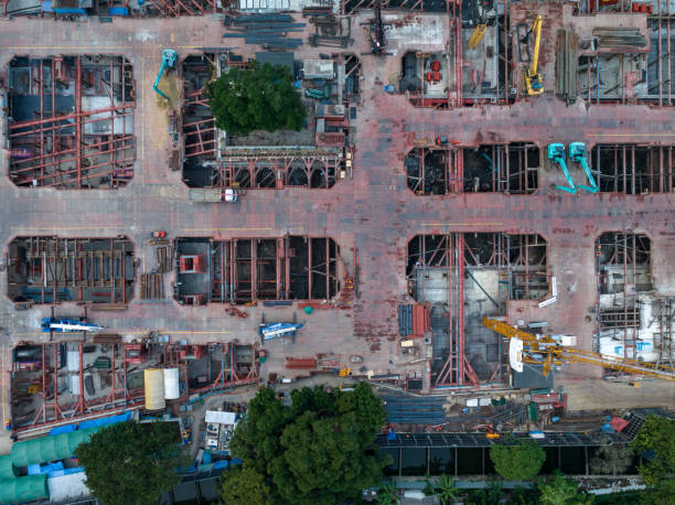 istock High angle aerial top down drone point of view over big building construction site with many huge crane and machine vehicle working daytime. Industrial business or civil engineering technology concept. 1485186306