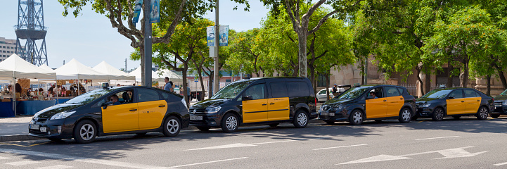Barcelona, Spain - June 08 2018: Row of black and yellow taxis parked by the beach.